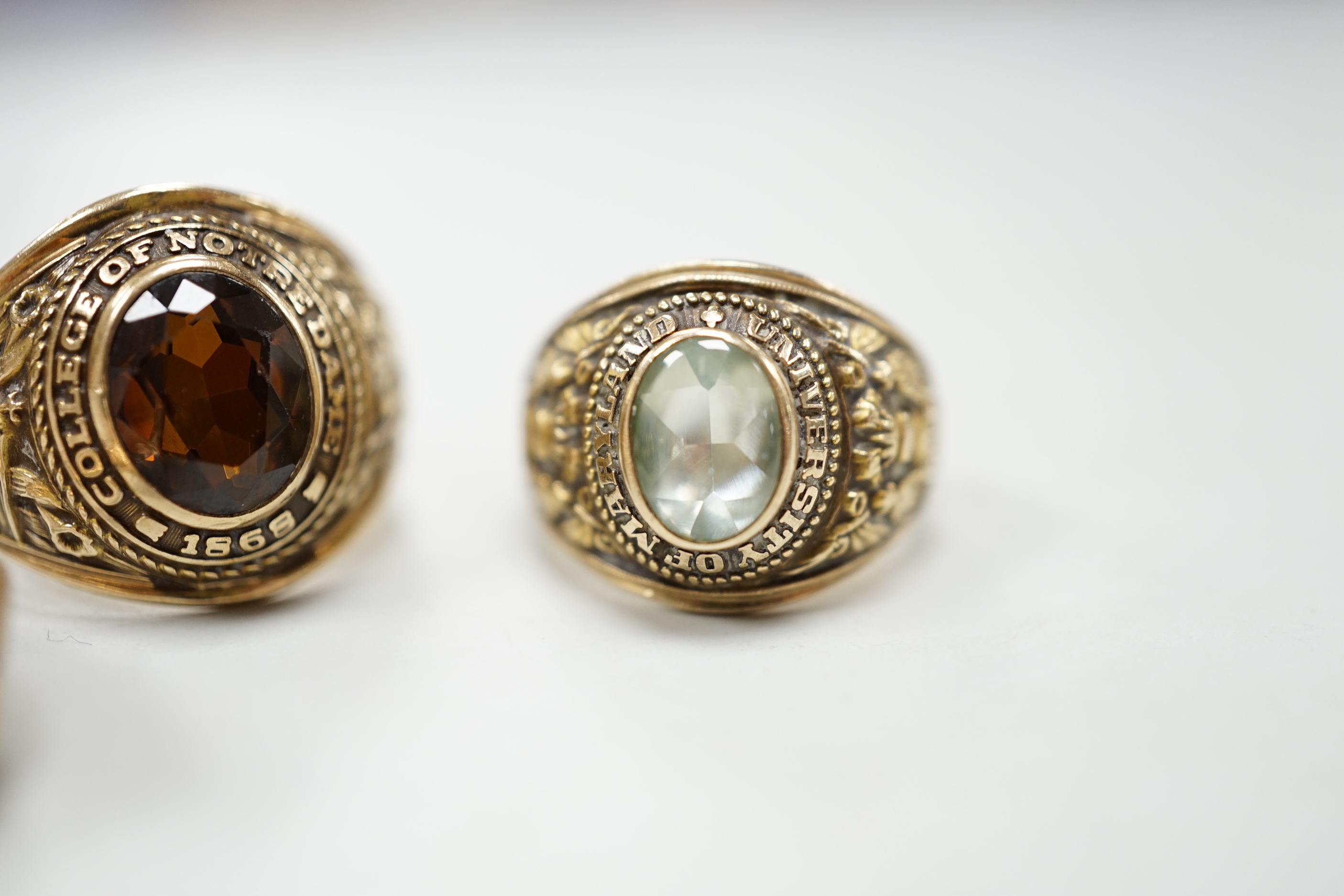 Three assorted American 10k dress rings, two set with gems, one signed John Roberts, gross weight 18.9 grams.